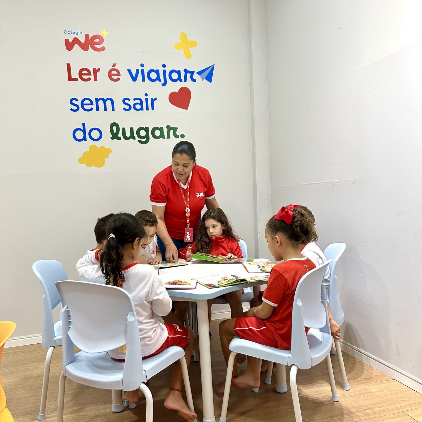 Professora e alunos lendo juntos no cantinho da leitura